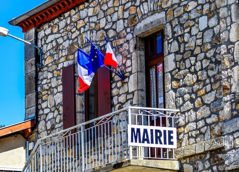 photo du fronton d'une mairie avec les drapeaux français et européen