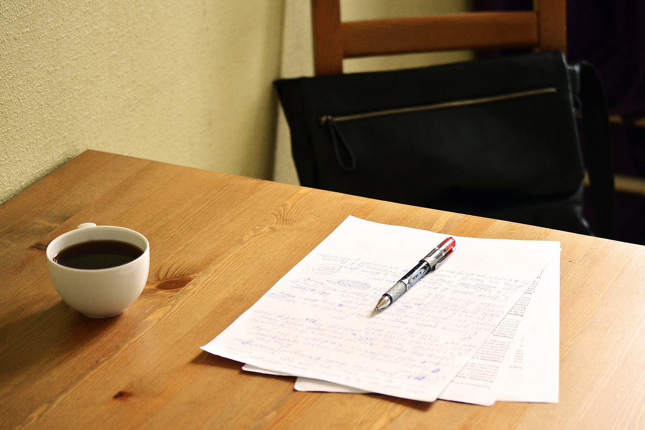 feuille de papier et stylo posés sur une table